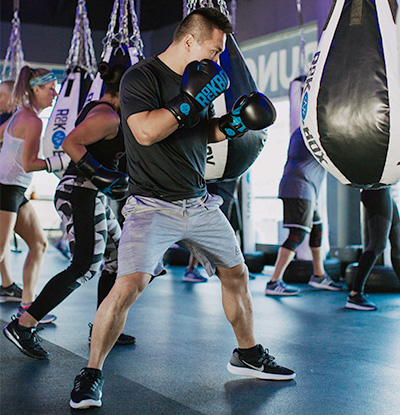 Man wearing boxing gloves ready to punch teardrop bag