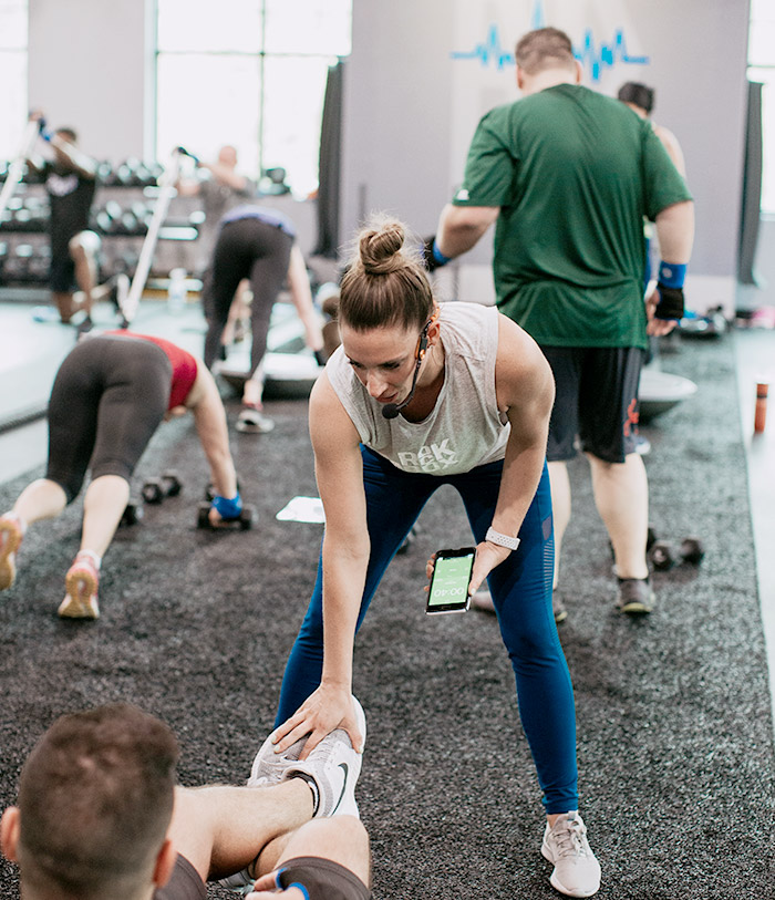 trainer holding phone talking to man as he does sit ups