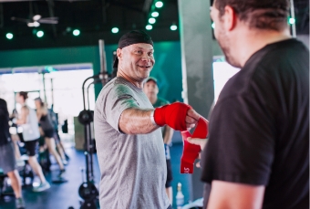 man getting glove from trainer