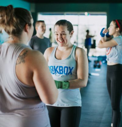 Two women talking inside of the gym